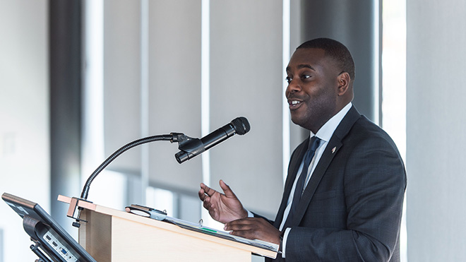 Gabe Amo speaking at a podium