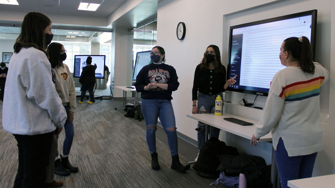 Three students present their website about human population. 