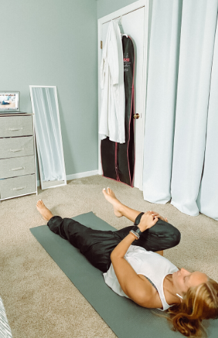 Person doing a yoga stretch on the floor.