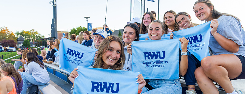 Students hold RWU flags at a sports game