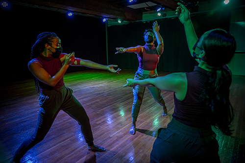 Three students dancing in a performance
