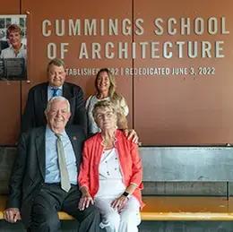 Joyce and Bill Cummings sit with President Miaoulis and his wife Heidi Maes in front of the Cummings School of Architecture sign