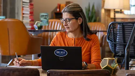 Lina Mejia working on her laptop computer.