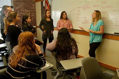 Students discuss advertising campaign strategy.