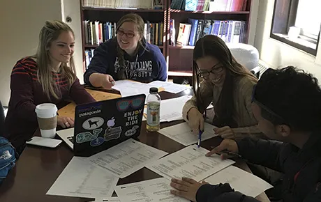 Students sift through data they collected from an election poll survey.