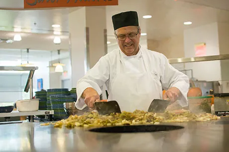 Chef prepares food in Upper Commons.