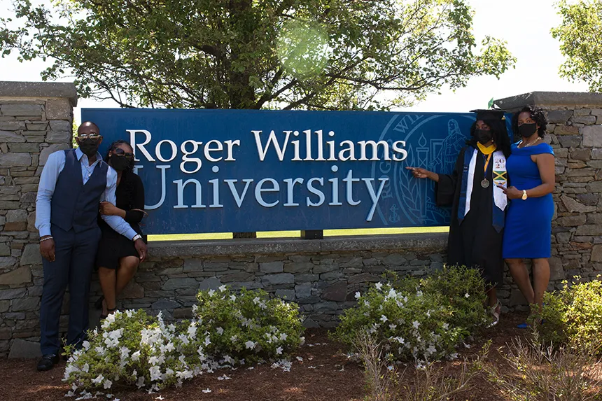 Image of a family posing with the Roger Williams University Sign