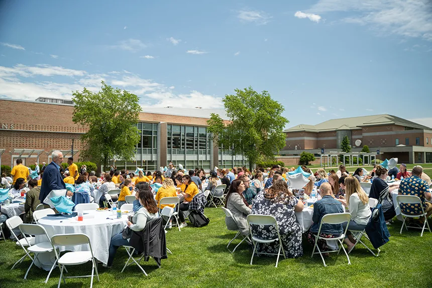 Tables of people on the Commons green for a BBQ