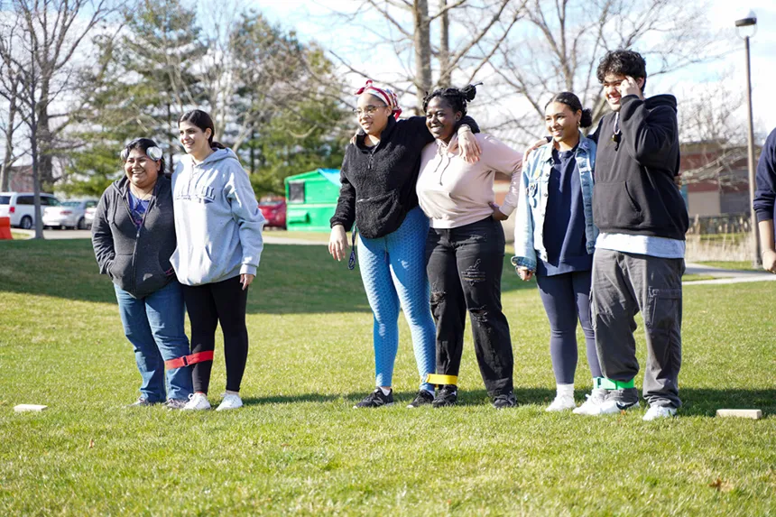 Three groups of students get ready for a three-legged race.