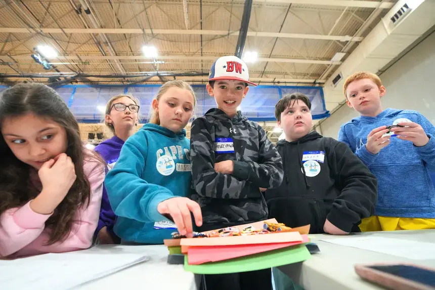 Fourth graders assemble a bridge entirely out of paper.