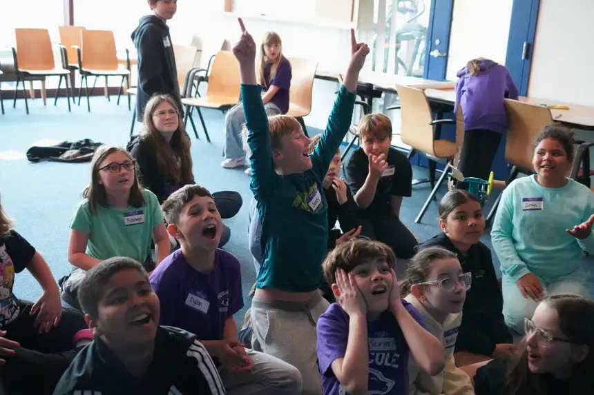 Fourth graders celebrate an outstanding performance by one group's wind turbine.