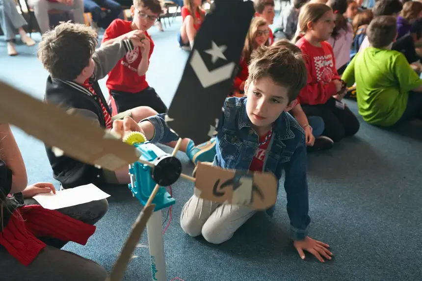 A fourth grader examines his wind turbine.