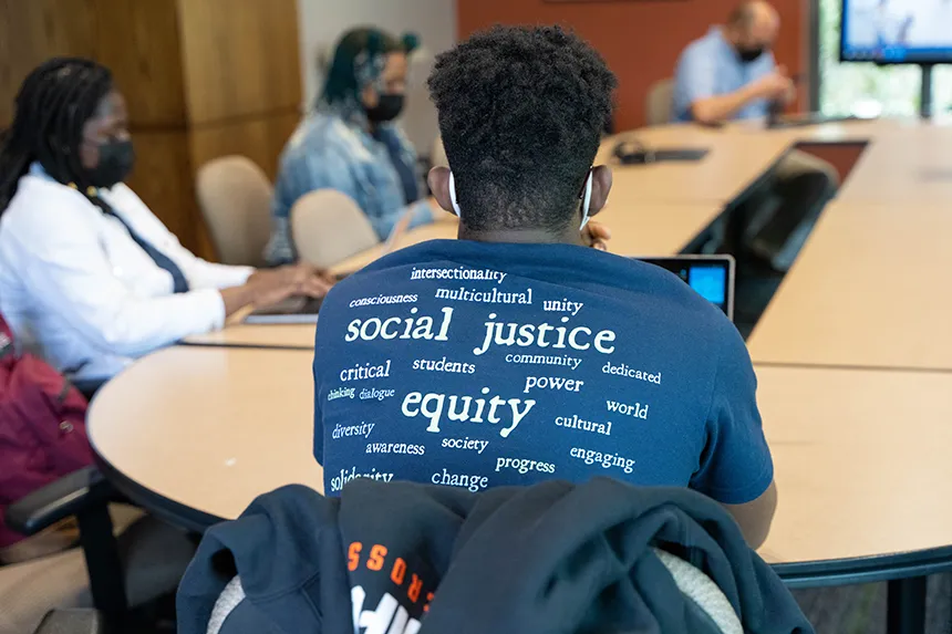 An MSU e-board member shows off the back of his e-board T-shirt.