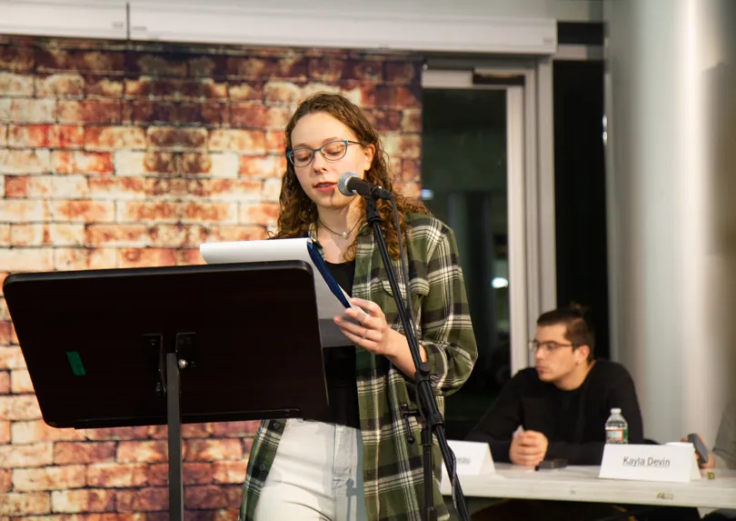 Poetry slam host at microphone.