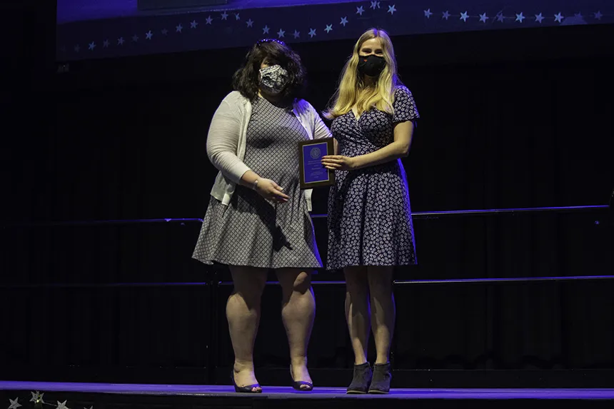 Student poses with award