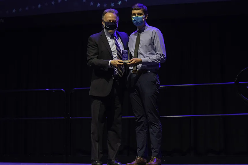 Student poses with award