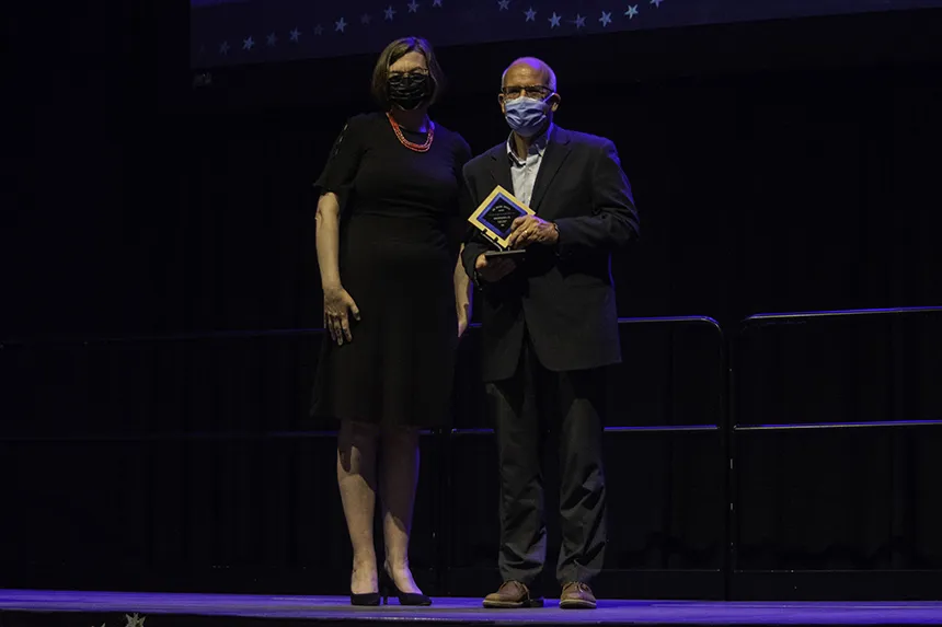 Professor poses with award