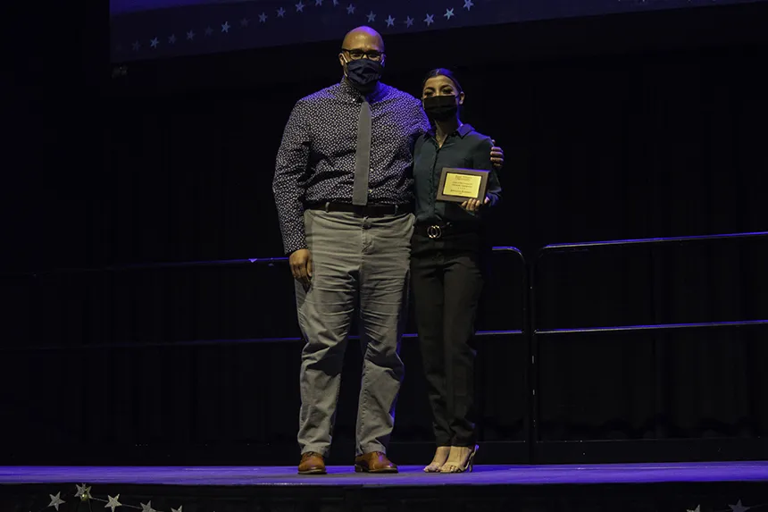 Student poses with award