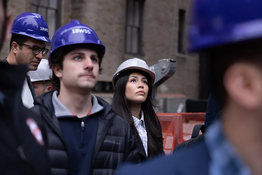 Students wear hard hats at a construction site