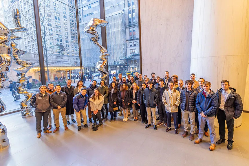Group of students in a building lobby with abstract sculptures