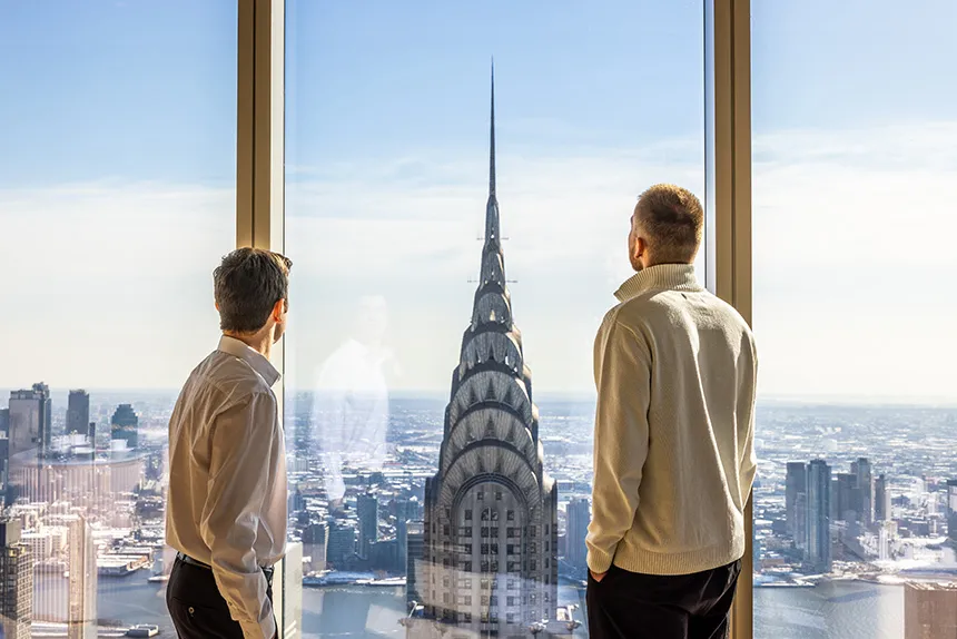 Students look at a building through a tall window in NYC